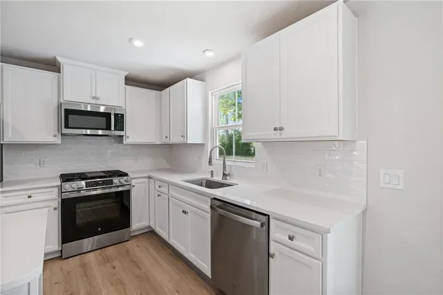 a kitchen with stainless steel appliances granite countertop a sink and a stove