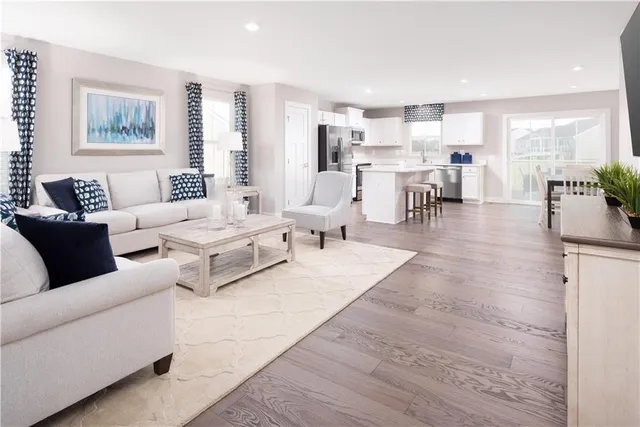 a living room with furniture and view of kitchen