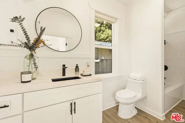 a bathroom with a toilet a sink and mirror