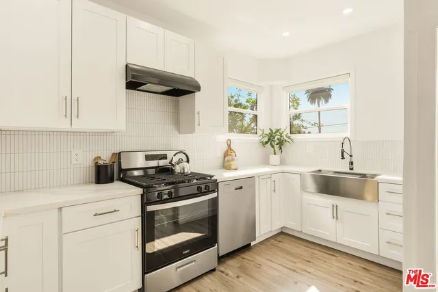 a kitchen with white cabinets and white appliances