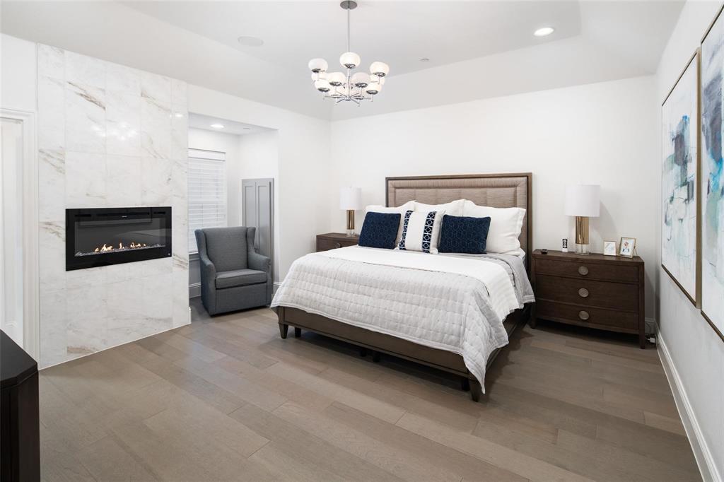818 Brett Drive Allen, TX 75013 - Photo 22 of 38 a spacious bedroom with a bed a couch and a flat screen tv