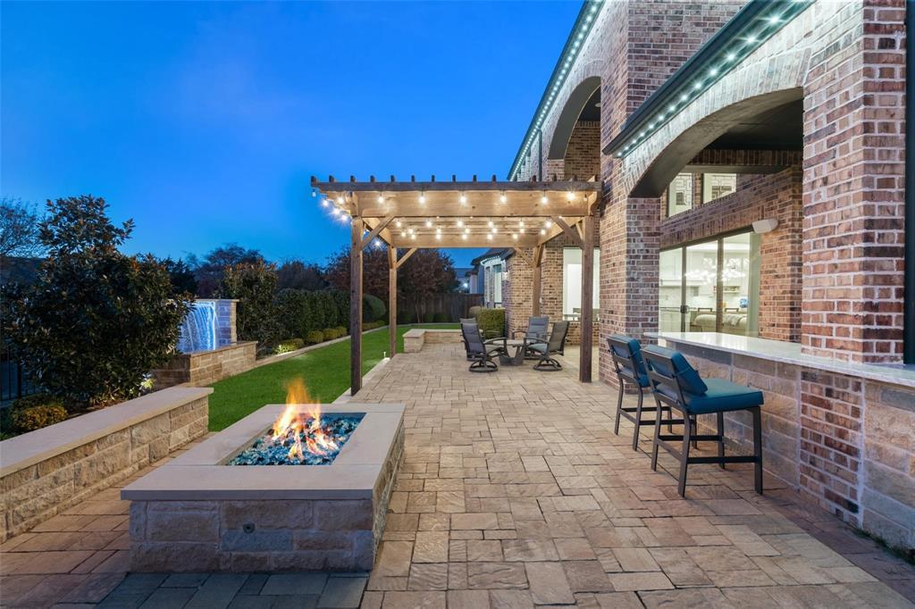 818 Brett Drive Allen, TX 75013 - Photo 34 of 38 a view of a patio with a dining table and chairs with a fire pit
