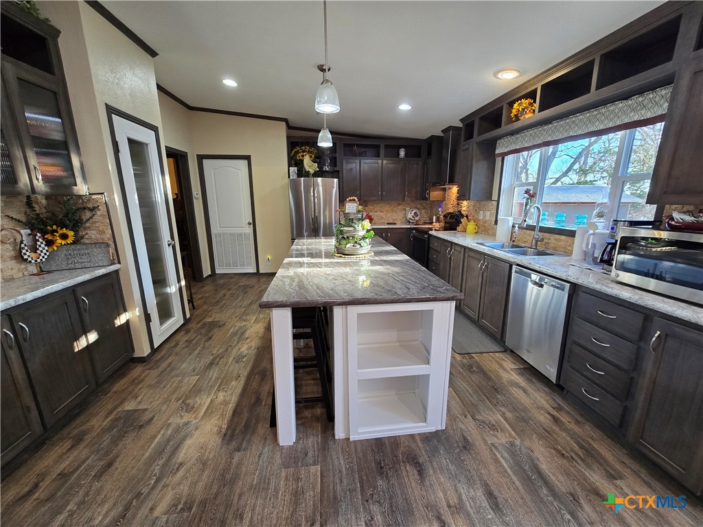390-400 North Fawn Ridge Drive Leander, TX 78641 - Photo 12 of 48 a kitchen with stainless steel appliances a dining table chairs stove refrigerator and wooden floor