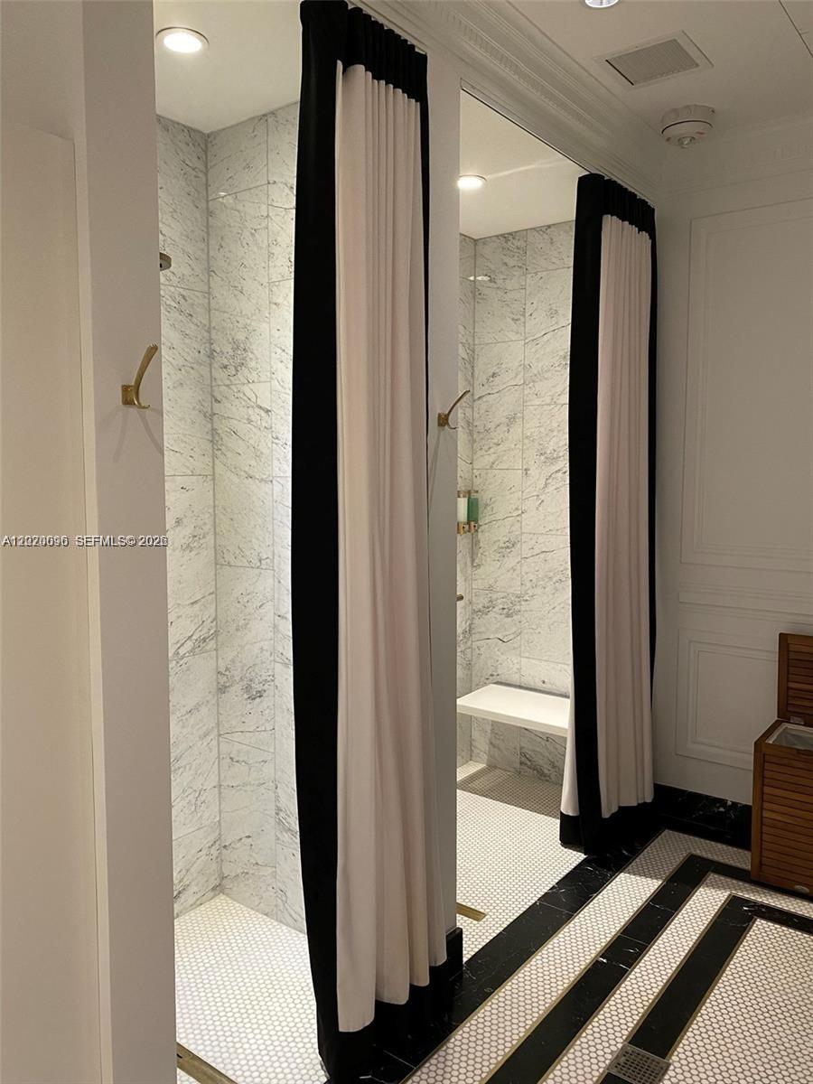 788 Northeast 23rd Street, Unit 1202 Miami, FL 33137 - Photo 58 of 64 a bathroom with a glass door shower and a mirror
