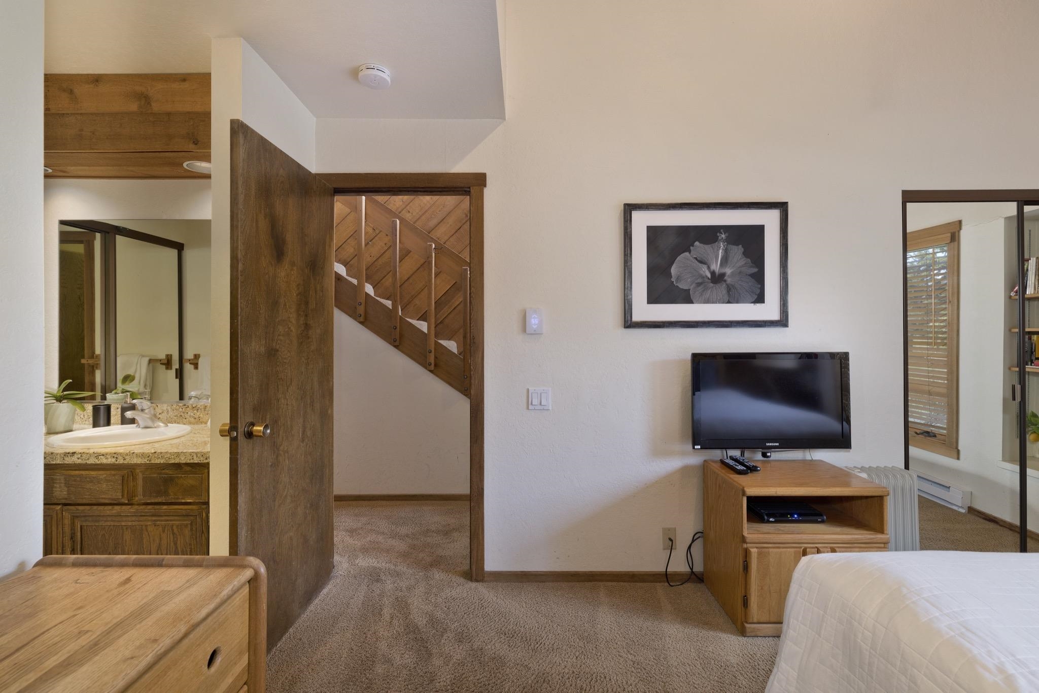 417 Snowcreek Road, Unit 417 Mammoth Lakes, CA 93546 - Photo 18 of 31 Carpeted room with a partial staircase, a bathroom with wood cabinetry and a vanity with a light-col