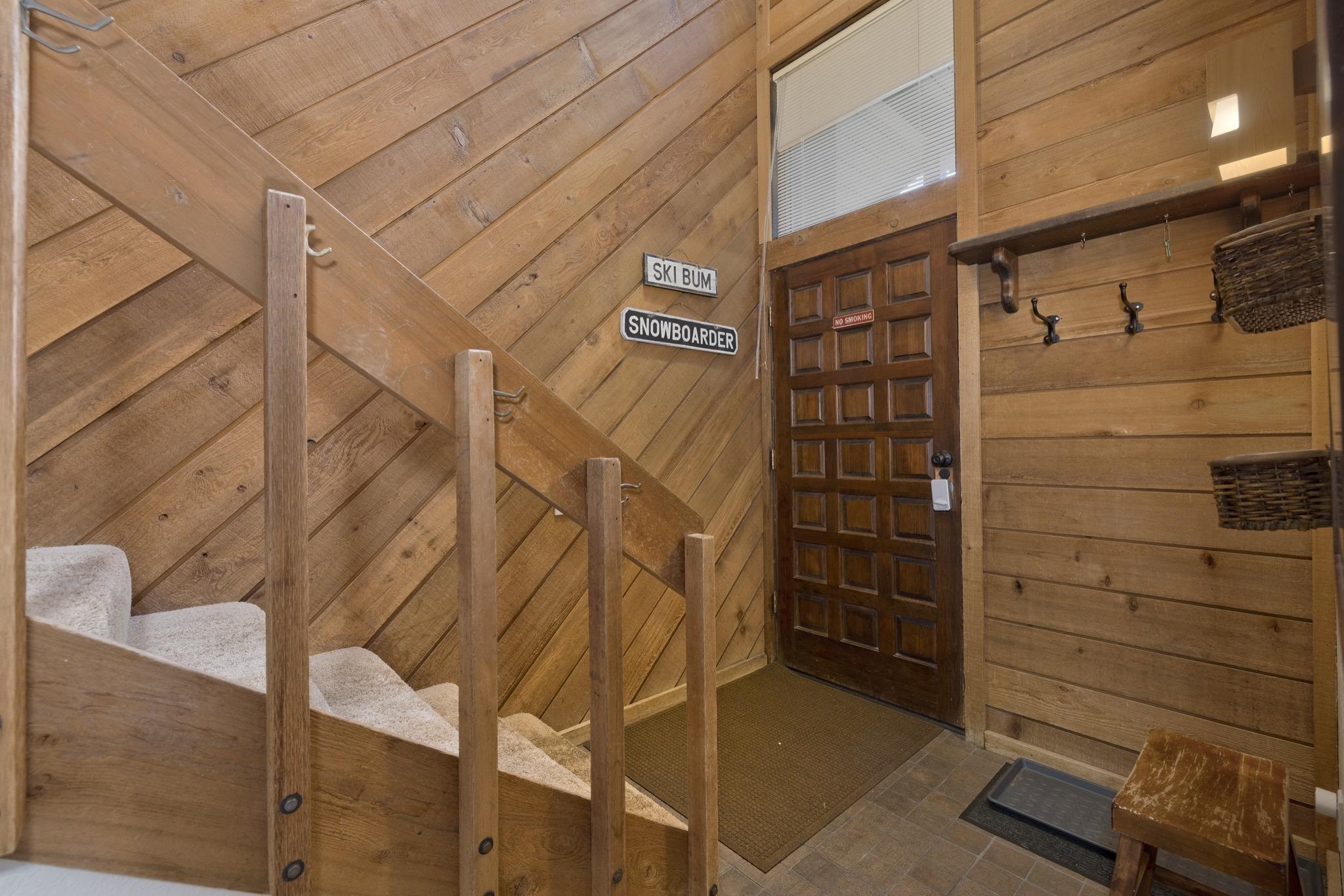 417 Snowcreek Road, Unit 417 Mammoth Lakes, CA 93546 - Photo 4 of 31 Entryway featuring a paneled wood door with an overhead transom window, wood-finish wall paneling, a