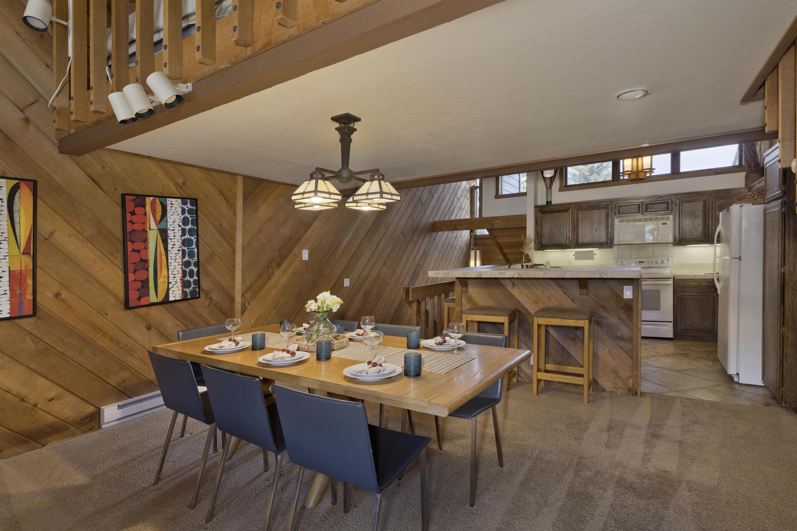 417 Snowcreek Road, Unit 417 Mammoth Lakes, CA 93546 - Photo 6 of 31 Dining area featuring wood-finish wall paneling, a multi-light chandelier, and carpet flooring