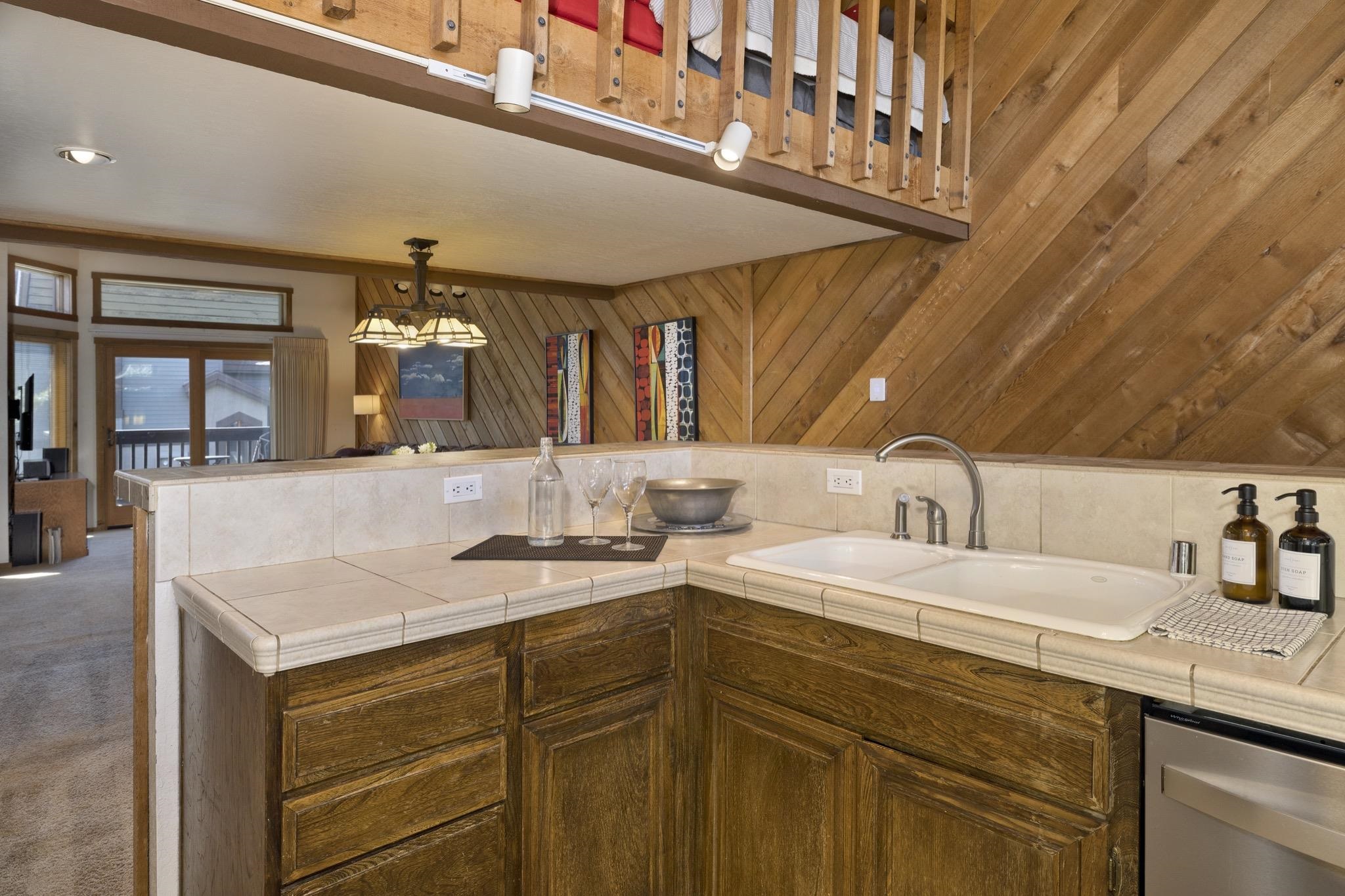 417 Snowcreek Road, Unit 417 Mammoth Lakes, CA 93546 - Photo 8 of 31 Kitchen featuring a tiled countertop, double basin sink with gooseneck faucet, and wood-finish cabinetry