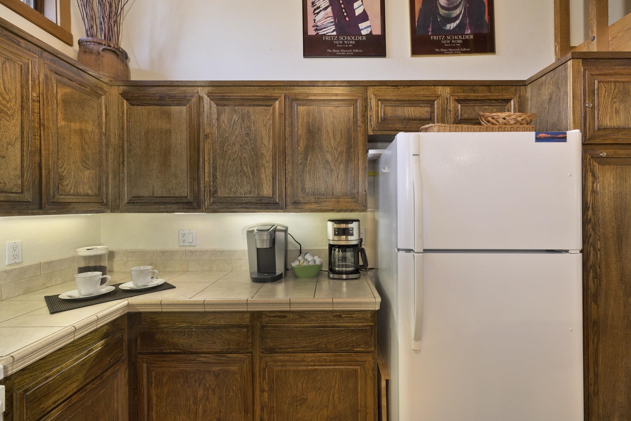417 Snowcreek Road, Unit 417 Mammoth Lakes, CA 93546 - Photo 9 of 31 Full-size refrigerator with wood-finish cabinetry, tile countertops, and under-cabinet lighting