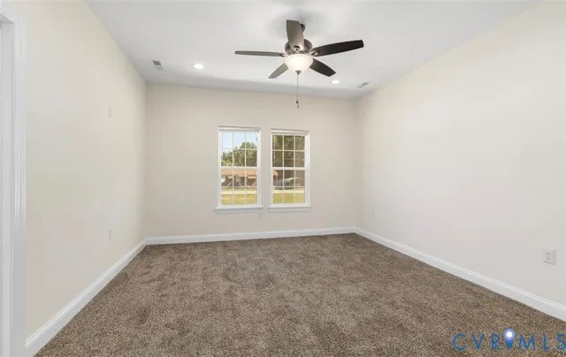 an empty room with a window and a ceiling fan