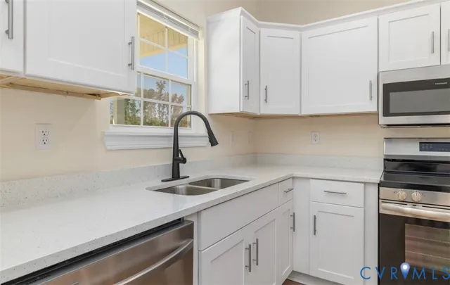 a kitchen with white cabinets a sink and dishwasher
