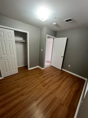 an empty room with wooden floor and closet