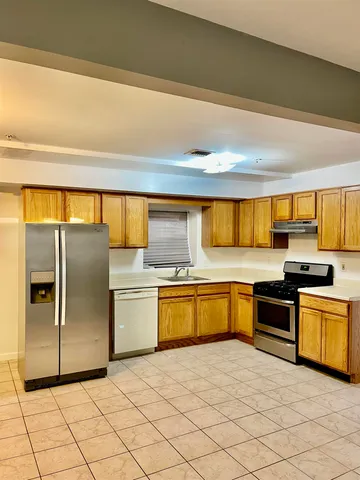 a kitchen with stainless steel appliances granite countertop a refrigerator and a stove top oven