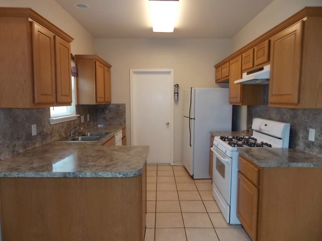 7315 Bethune Avenue, Unit A Austin, TX 78752 - Photo 4 of 8 a kitchen with a stove a sink and a refrigerator