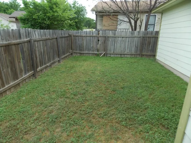 a view of a backyard with wooden fence