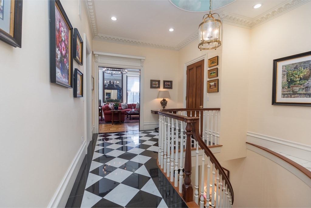 129 Beacon Street, Unit 1 Boston, MA 02116 - Photo 17 of 42 a hallway with dining room and chandelier