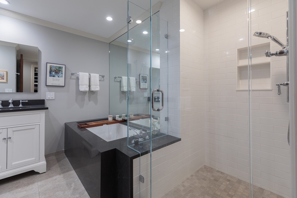 129 Beacon Street, Unit 1 Boston, MA 02116 - Photo 26 of 42 a bathroom with a granite countertop sink a toilet a shower and a mirror