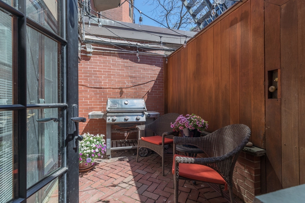 129 Beacon Street, Unit 1 Boston, MA 02116 - Photo 35 of 42 a backyard of a house with table and chairs