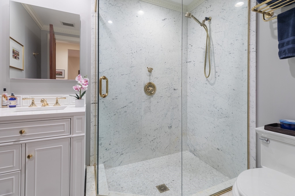 129 Beacon Street, Unit 1 Boston, MA 02116 - Photo 36 of 42 a bathroom with a shower sink vanity and mirror