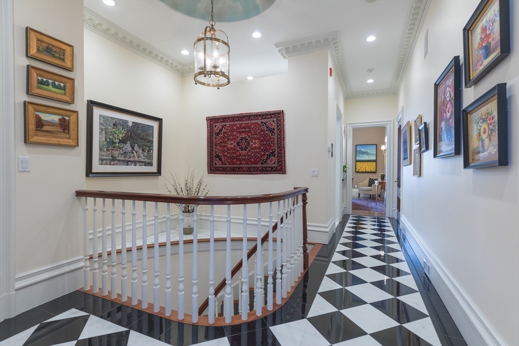 129 Beacon Street, Unit 1 Boston, MA 02116 - Photo 6 of 42 a view of staircase with lots of frames on wall and paintings on the wall