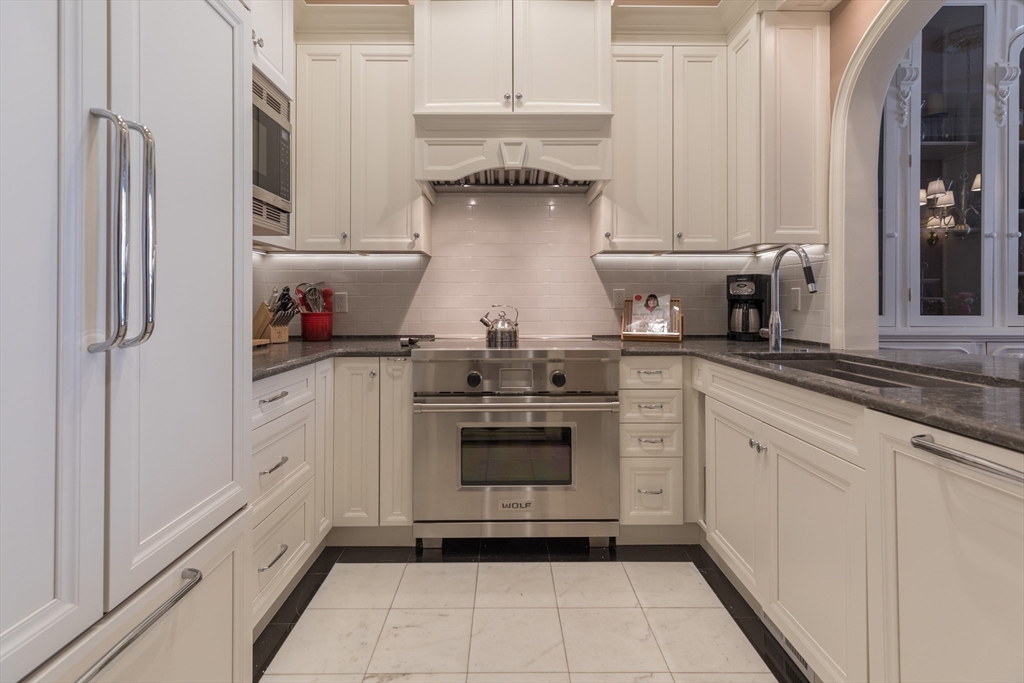 129 Beacon Street, Unit 1 Boston, MA 02116 - Photo 9 of 42 a kitchen with stainless steel appliances granite countertop a stove and a refrigerator