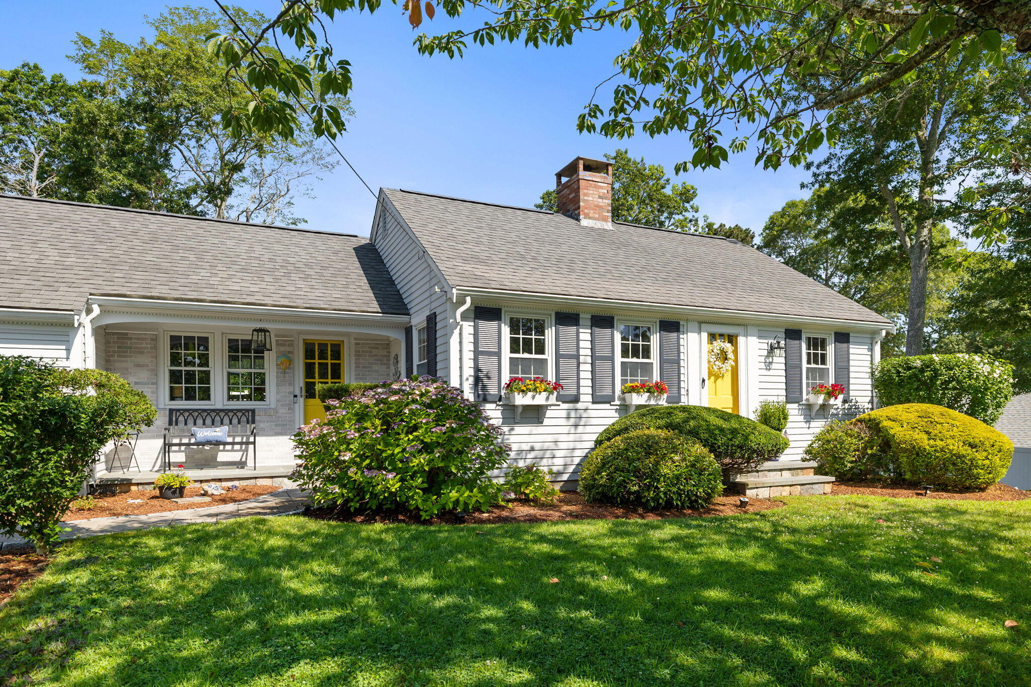 a view of a house with a yard and potted plants