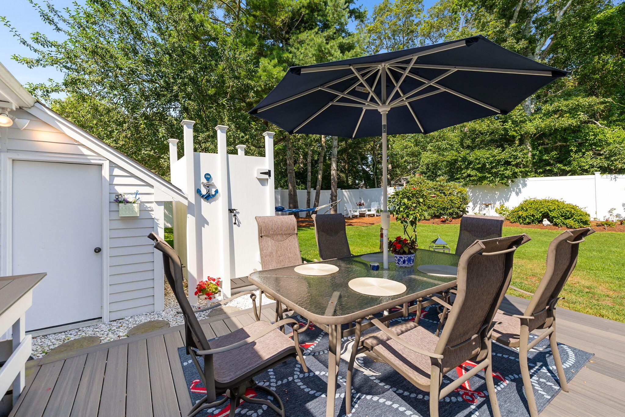 26 Captain Chase Road South Yarmouth, MA 02664 - Photo 46 of 54 a patio with wooden floor a yard a table and chairs