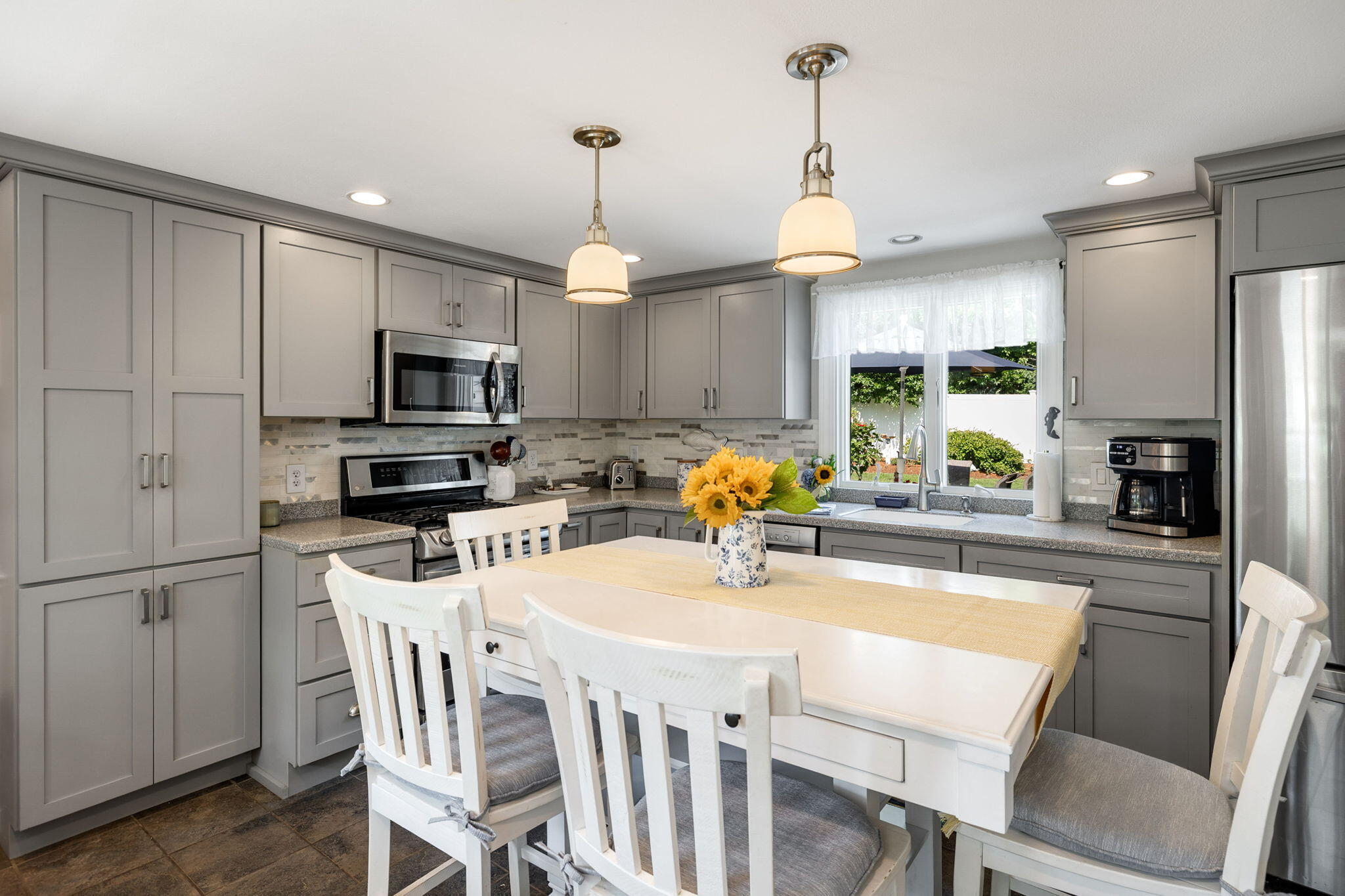 26 Captain Chase Road South Yarmouth, MA 02664 - Photo 6 of 54 a kitchen with a dining table chairs stainless steel appliances and cabinets