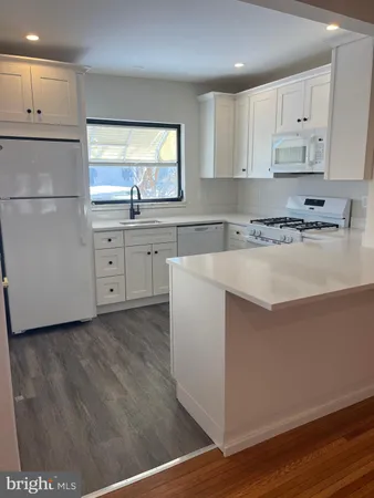 a kitchen with cabinets appliances a sink and a window