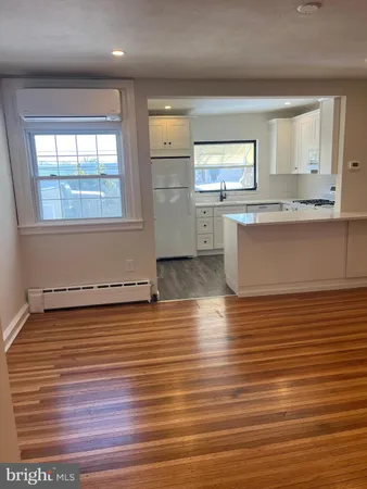 an empty room with wooden floor and window