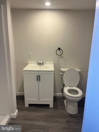 a white toilet sitting next to a white sink and vanity