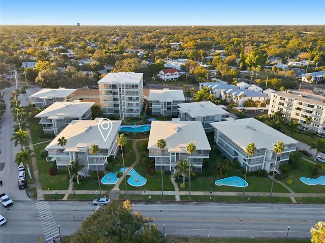an aerial view of residential houses with outdoor space and parking