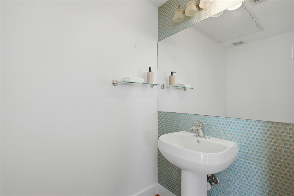 2111 Clark Street, Unit H Dallas, TX 75204 - Photo 14 of 37 a bathroom with a sink a mirror and toilet