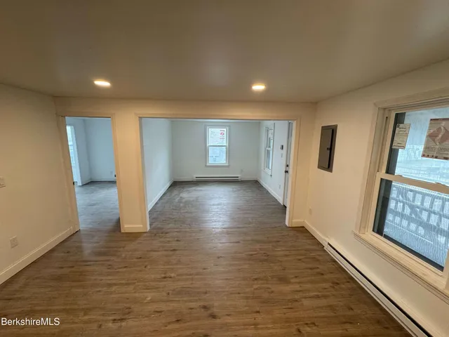 a view of a room with wooden floors and window