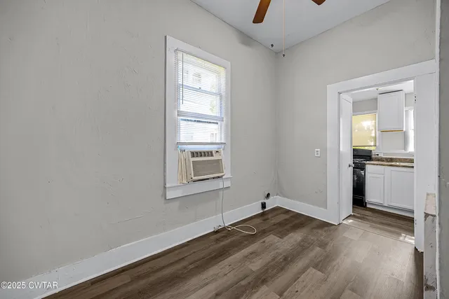 a view of a kitchen with wooden floor and electronic appliances