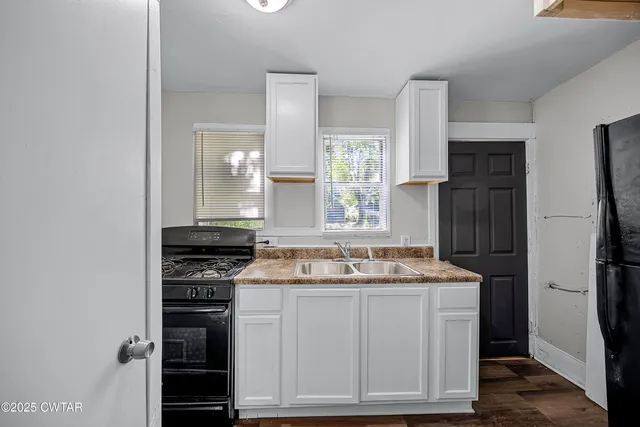a kitchen with granite countertop a refrigerator and a sink