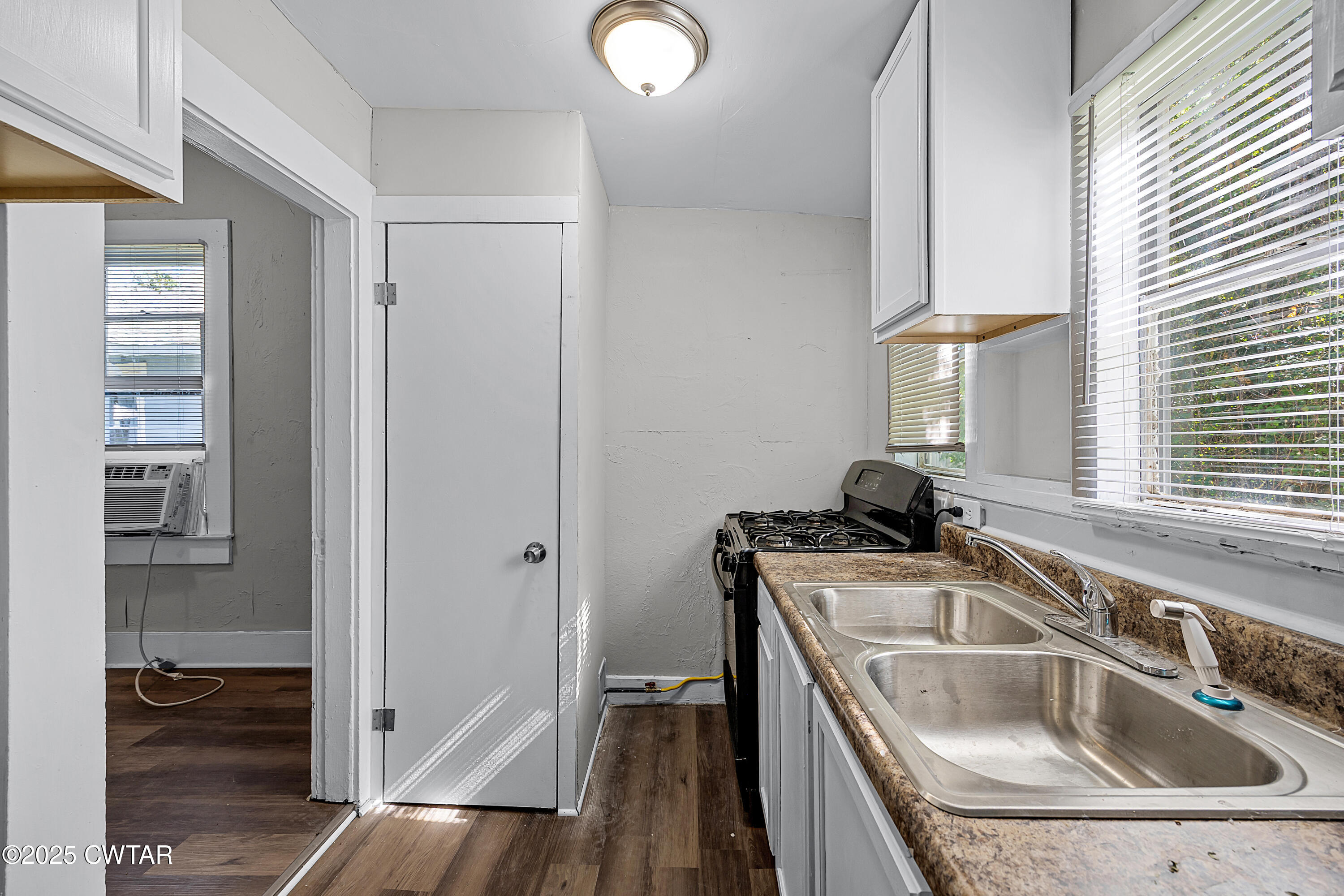 220 Division Avenue Jackson, TN 38301 - Photo 15 of 15 a kitchen that has a sink and a stove with wooden floor