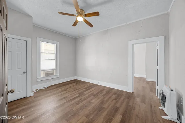 an empty room with closet and windows