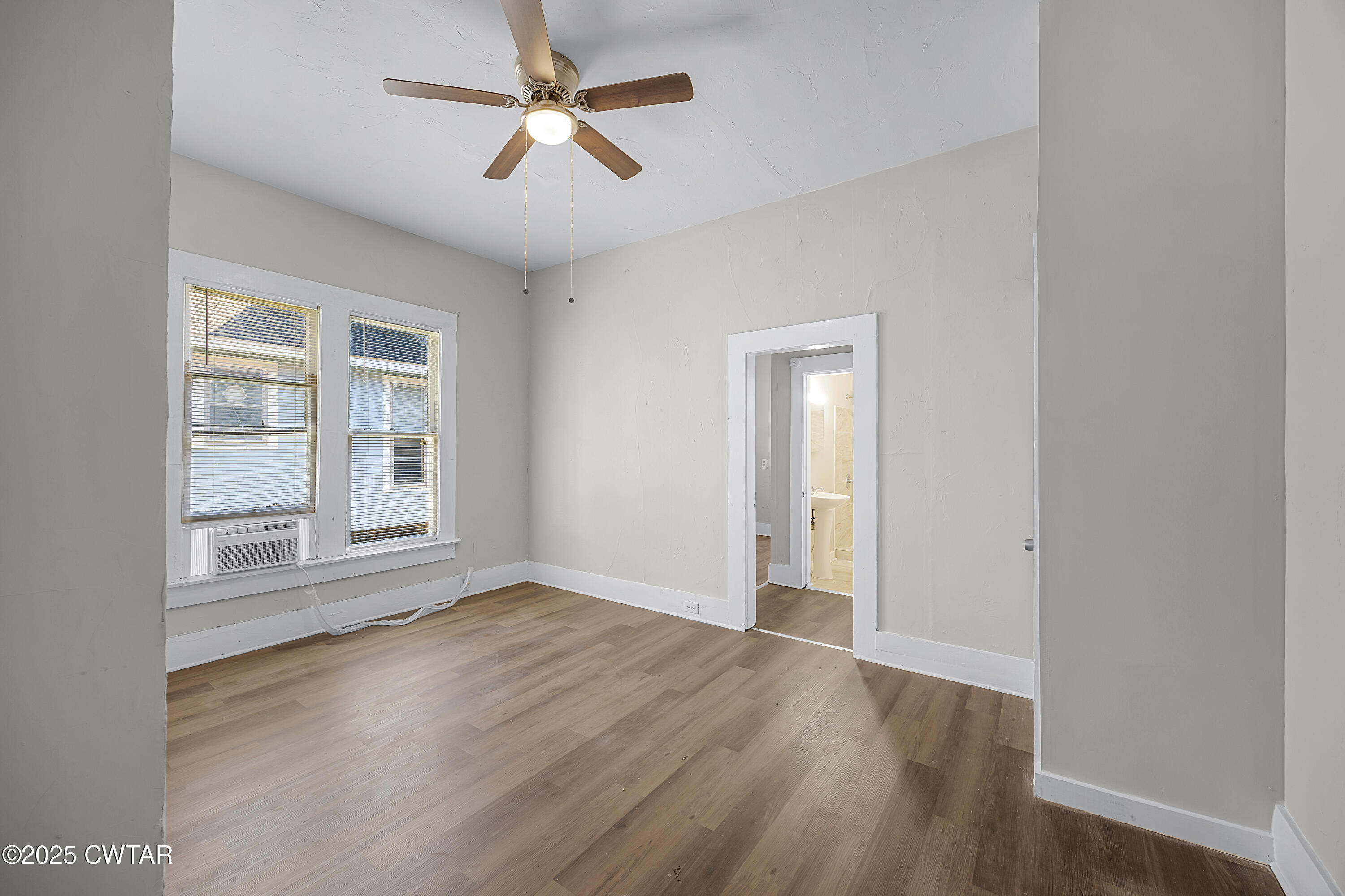 220 Division Avenue Jackson, TN 38301 - Photo 7 of 15 an empty room with wooden floor chandelier fan and windows