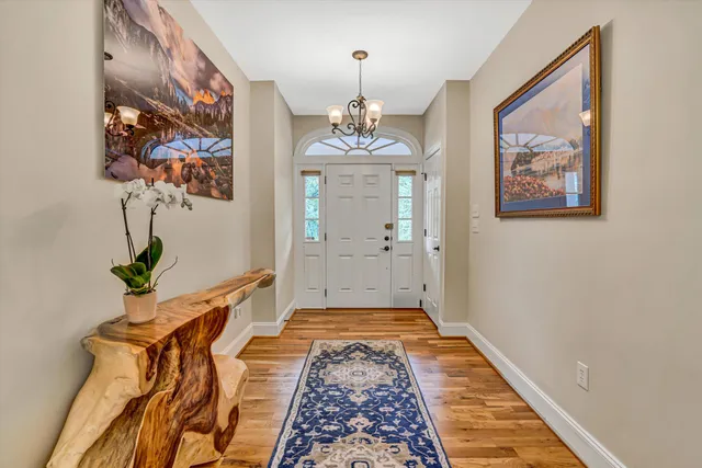 a living room with furniture a chandelier and a rug
