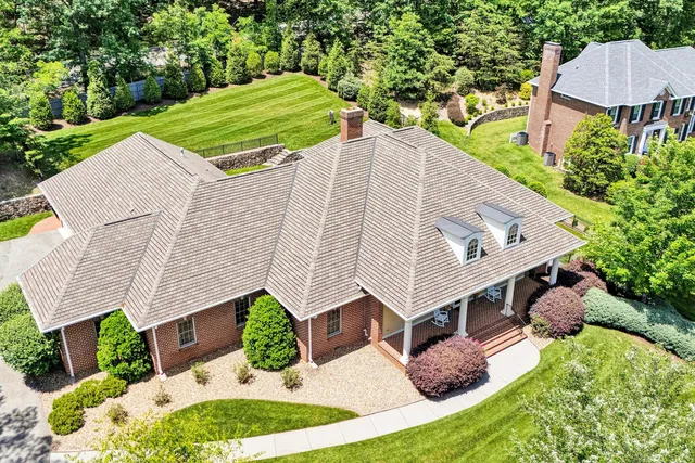 a aerial view of a house with a yard and trees