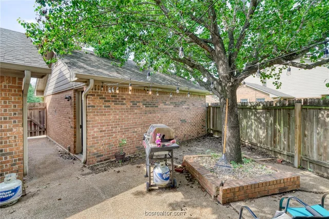 a backyard of a house with fountain table and chairs