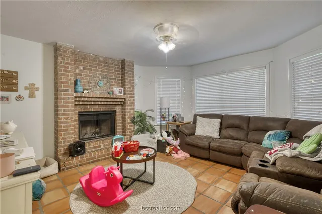 a living room with furniture a fireplace and a flat screen tv