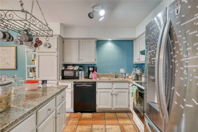 a kitchen with stainless steel appliances granite countertop a sink and cabinets