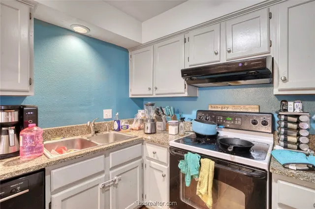 a kitchen with stainless steel appliances granite countertop a sink a stove and cabinets