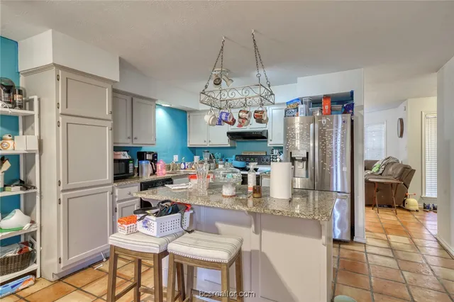 a kitchen with refrigerator and cabinets