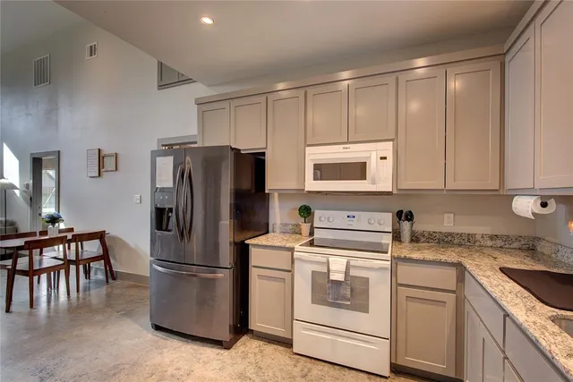 a kitchen with appliances a sink and a refrigerator