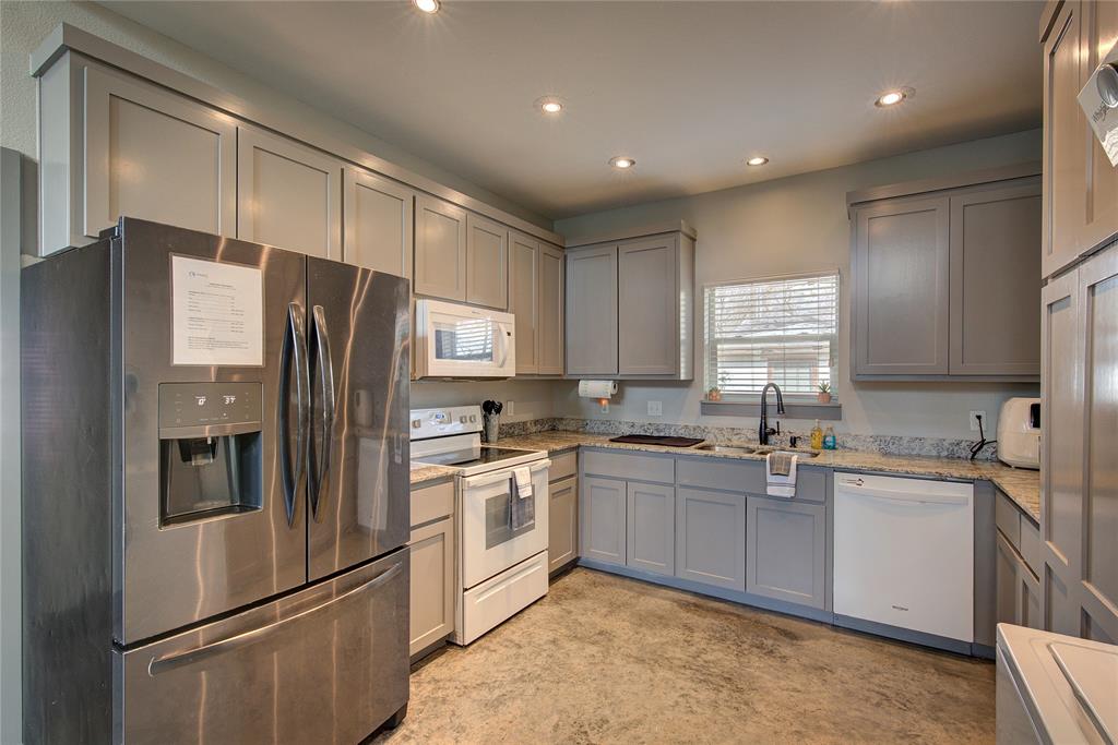 600 Maple Street Commerce, TX 75428 - Photo 13 of 35 a kitchen with stainless steel appliances granite countertop a refrigerator sink and stove