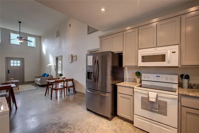 a kitchen with stainless steel appliances granite countertop a refrigerator stove microwave and sink