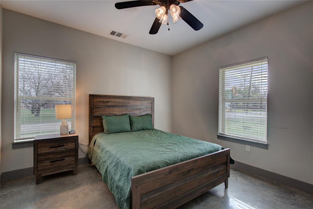 600 Maple Street Commerce, TX 75428 - Photo 18 of 35 a bed sitting in a bedroom next to a window